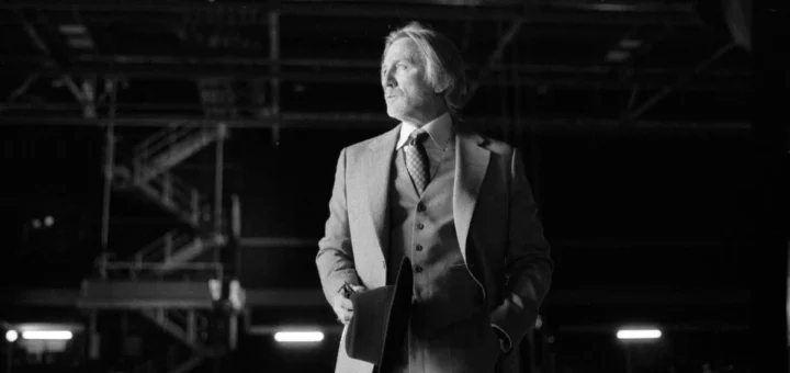 A cinematic poster for 'Wake Up Dead Man' featuring a dark, moody aesthetic with bold title text, suggesting a mystery or thriller theme, possibly with shadowy figures or crime scene elements in the background.